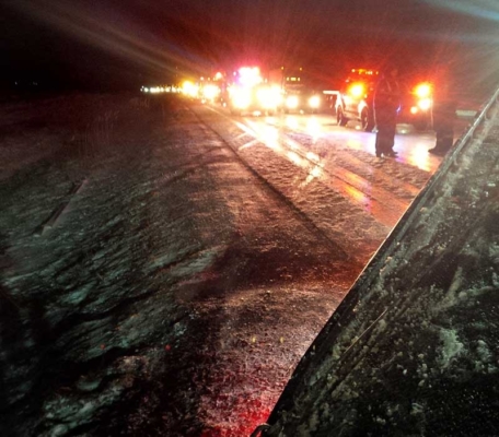 Emergency vehicles stopped on the icy roadway on Highway 401. 