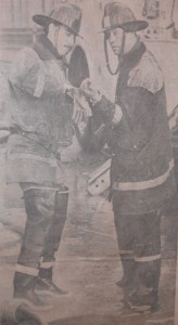 London Firemen Morley Hanes, left, and Don Varey stop for a moment to attend to an injury to Mr. Varey's hand. (photo by Rick Eglington of The London Free Press)