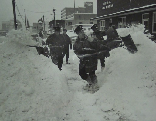 London Firemen, trained in battling the heat, took on the cold Thursday, shoveling the 10.5 inch snowfall at Central Fire Station. From left are Wayne Hauser, Jim Brown, and Tom Timmins.