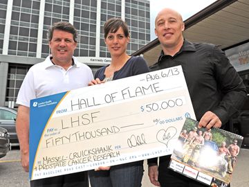 LHSF Executive Vice President John MacFarlane proudly accepts a cheque in the amount of $50,000 from London firefighters Allison Vickard and Bob Geilen, co-chairs of the Hall of Flame Calendar committee. (Photo by Mike Maloney, London Community News)