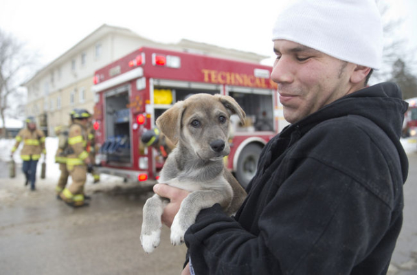  Hani El-Shourafa holds Bailey, a 10-week-old shepherd-husky mix, who was rescued by firefighters from a three-storey apartment building on Westlake St. in London on Thursday. Firefighters rescued some residents using ladders after heavy smoke trapped them in third-floor units. No one was injured. (CRAIG GLOVER/The London Free Press/QMI Agency)