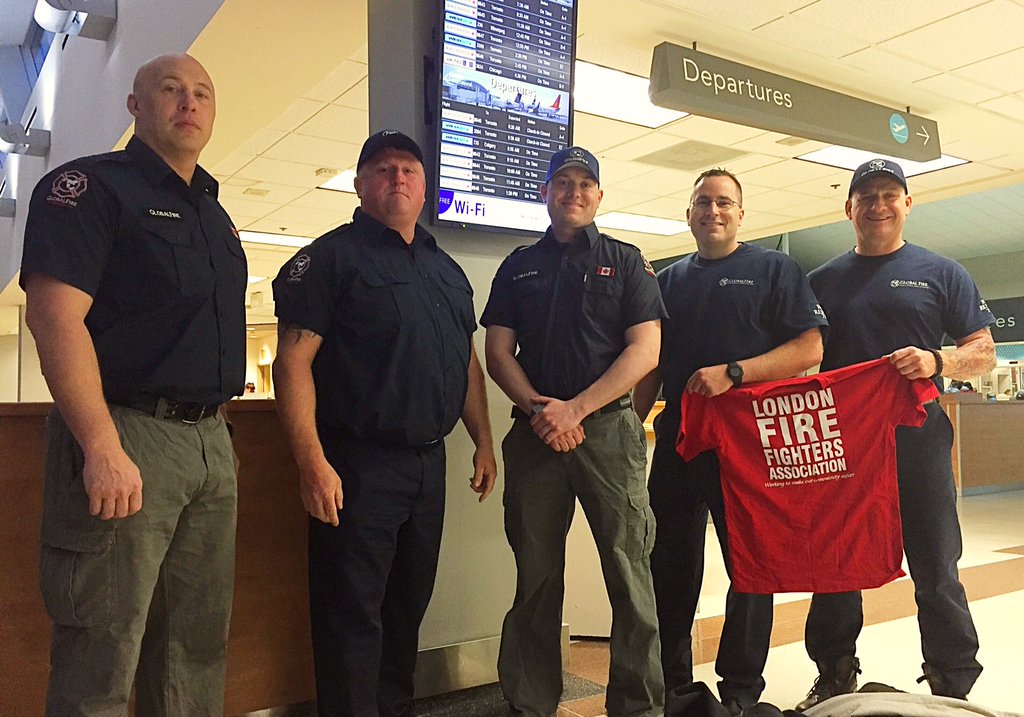 Five London Fire fighters pose as they are getting ready to fly out to Alberta