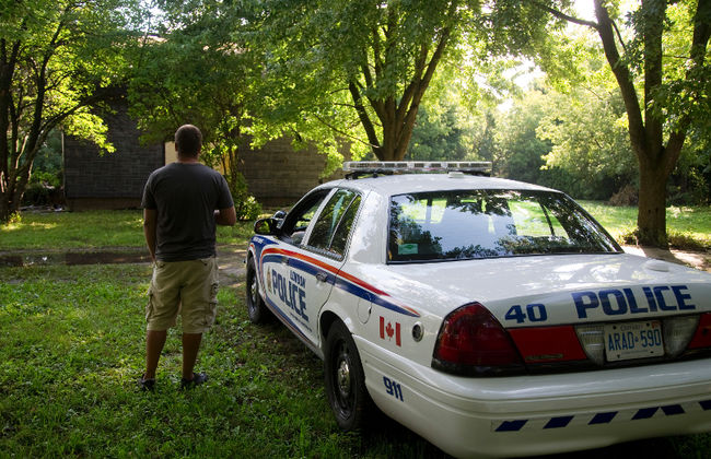 The owner of the property talks to a police officer guarding the scene, after an overnight fire on Trafalgar St. near Bancroft Road in London, Ont. on Friday August 26, 2016. The owner of the property said that the house was due to be demolished anyway shortly. The owner said he checked the property daily and kept the building secured. (MIKE HENSEN, The London Free Press)