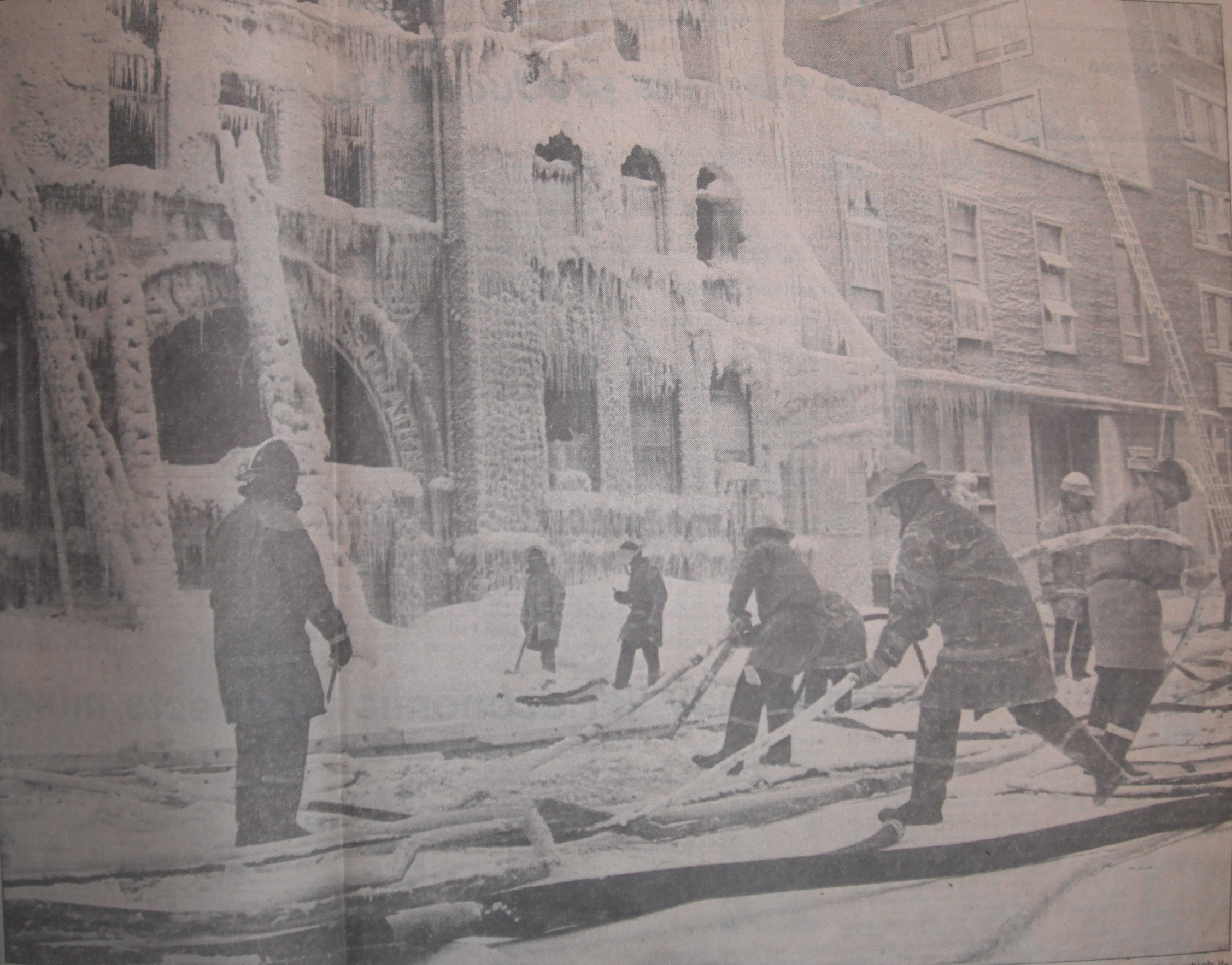 Firefighters pulling frozen lines from the ice that formed during the fire at the YM-YWCA fire.