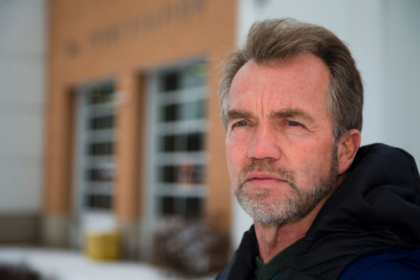 Retired fire fighter poses in front of Station 1