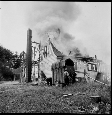 Burning home with most of the roof burned off.