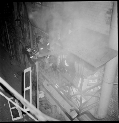 Four fire fighters battling smoke on a second floor fire escape