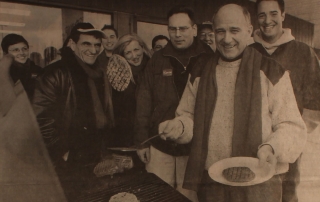 Glen Pearson flipping burgers at a barbecue with campaign supporters