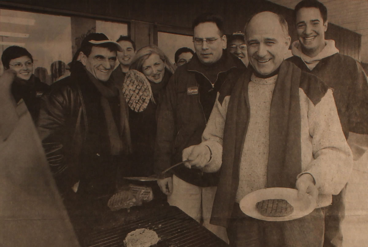 Glen Pearson flipping burgers at a barbecue with campaign supporters