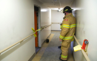 London firefighter Randy Geene waits for an investigator from the Ontario Fire Marshal's office to arrive at the scene of an apartment fire at 85 Walnut St. in London on Sunday. Mike Hensen/The London Free Press/Postmedia Network