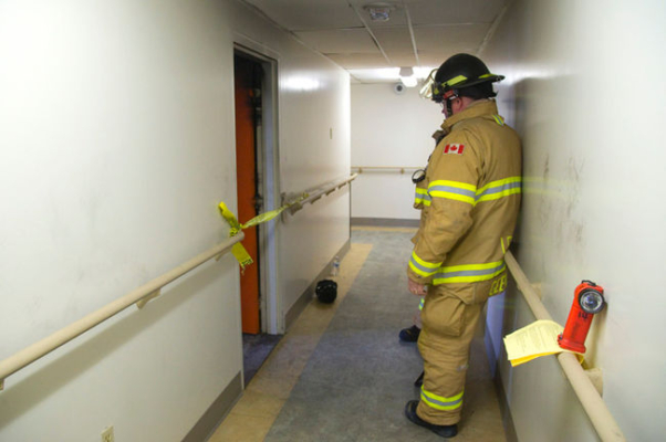 London firefighter Randy Geene waits for an investigator from the Ontario Fire Marshal's office to arrive at the scene of an apartment fire at 85 Walnut St. in London on Sunday. Mike Hensen/The London Free Press/Postmedia Network
