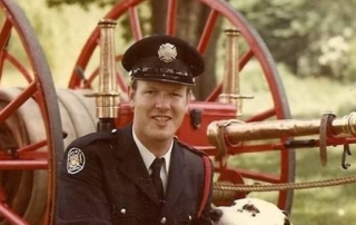 Fire fighter Scott Carter posing with Mascot Ember, a dalmatian dog.