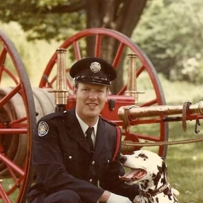Fire fighter Scott Carter posing with Mascot Ember, a dalmatian dog.