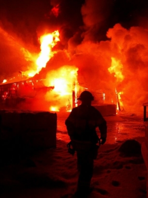 Fire fighter silhouette with large fire behind