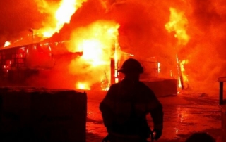 Fire fighter silhouette with large fire behind