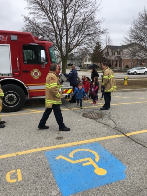 Fire fighters showing the fire engine to public school students