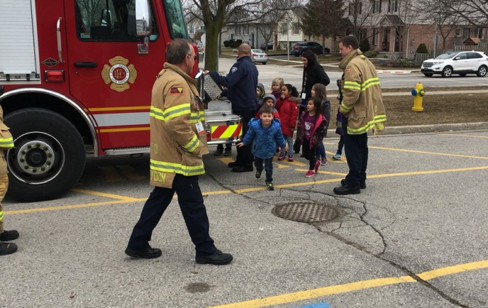 Fire fighters showing the fire engine to public school students