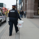 Police officer walking with plastic bucket