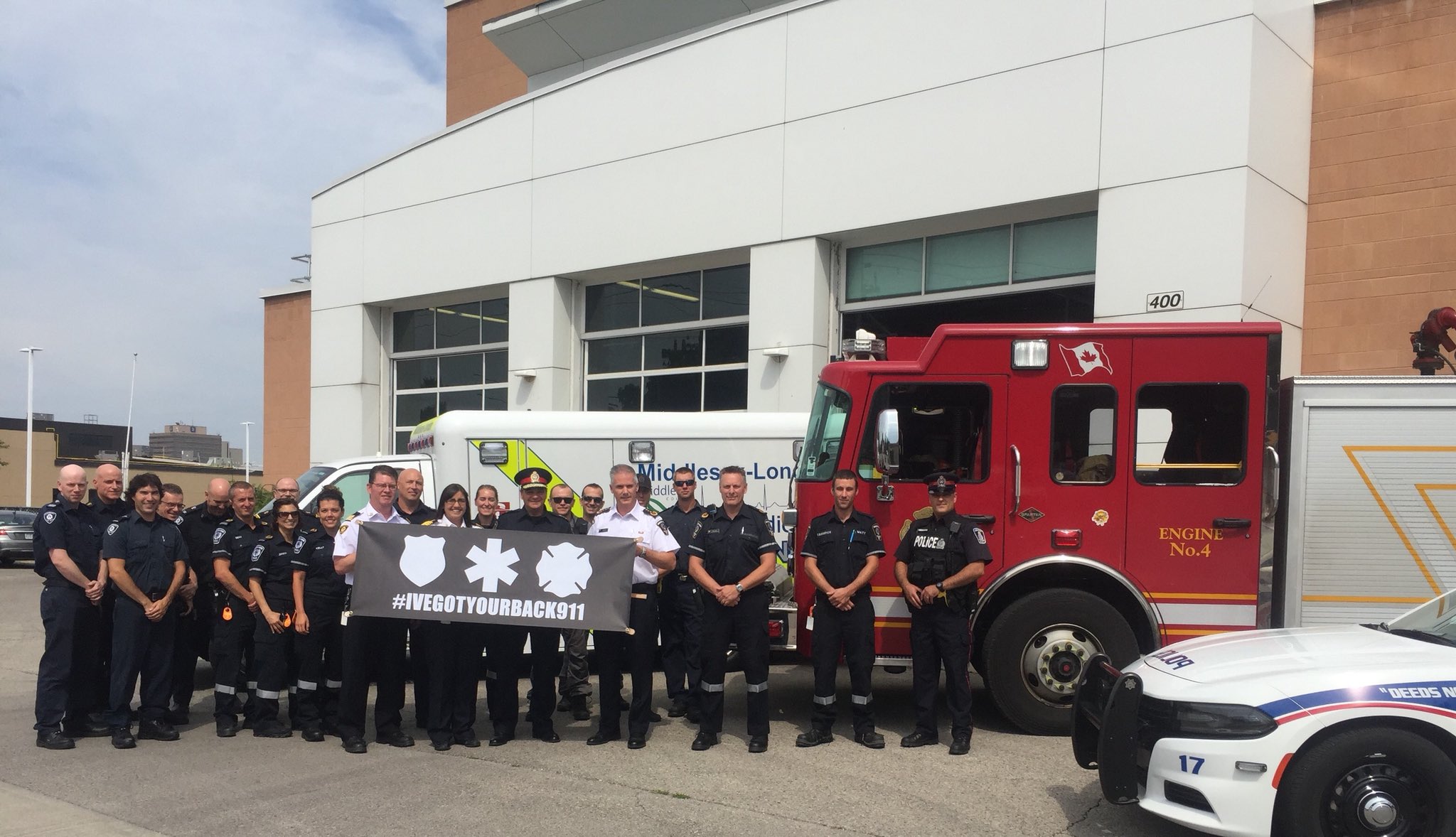 EMS, Police, & Fire Personnel posing in front of their emergency vehicles holding a poster for the I've Got Your Back campaign.