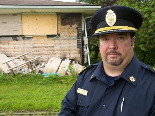 Acting deputy fire chief Jack Burt shows how a December butane THC-extraction blast blew the bricks off the walls of this Hamilton Road home.