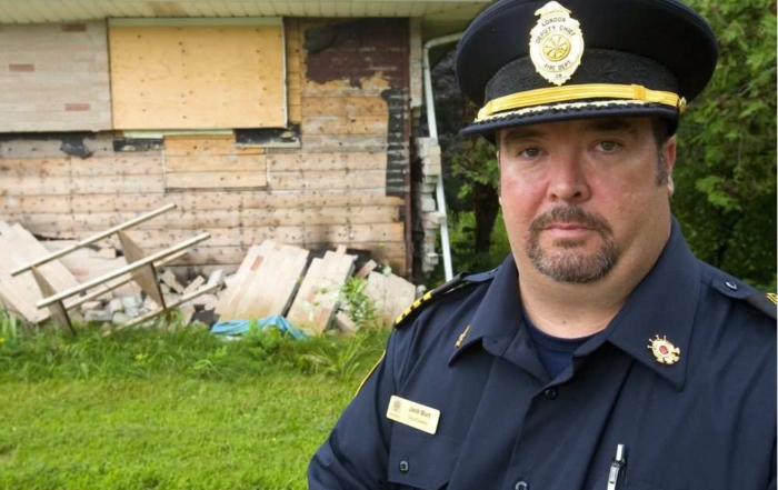 Acting deputy fire chief Jack Burt shows how a December butane THC-extraction blast blew the bricks off the walls of this Hamilton Road home.