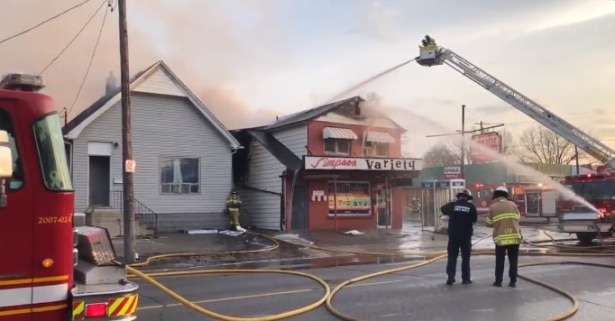 Large fire truck pouring water on burning building