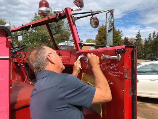 Captain Brydon signing the inside panel of the Captain's door