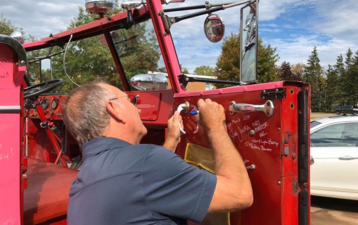 Captain Brydon signing the inside panel of the Captain's door