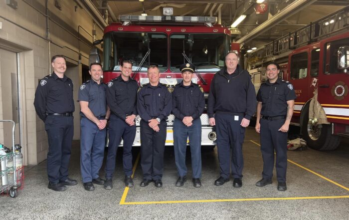 Fire fighters posing in front of a fire truck