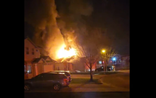 Large fire coming from the roof of a house during the night.