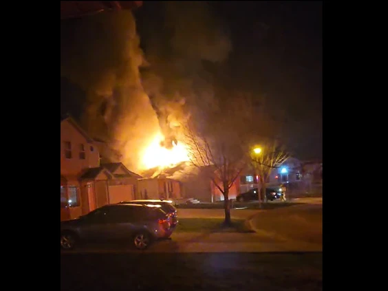 Large fire coming from the roof of a house during the night.