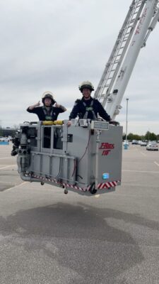 Firefighter with city councilor in platform truck, TRex