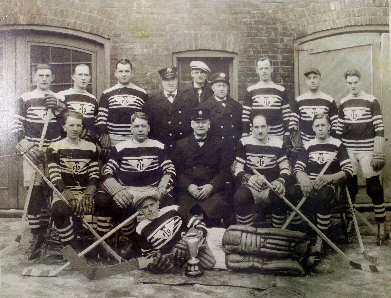 London Fire Department hockey team proudly poses with the Mayor's Cup after beating the Police Dept hockey team.