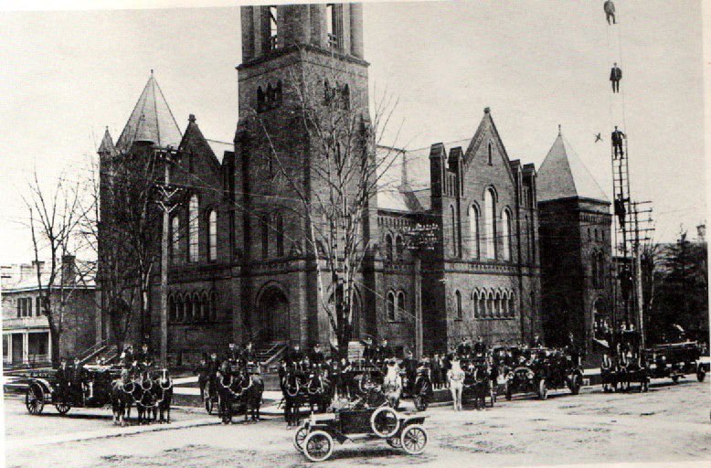 The Fire Department personnel posing with the apparatus in front of the Methodist Church on Dundas St at Maitland St.