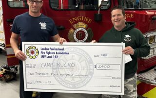 FF Sean Foxton presenting a cheque to Camp BUCKO representative.