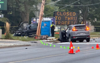 Two vehicles involved in collision with broken hydro pole visible. One vehicle on the front lawn of a home.