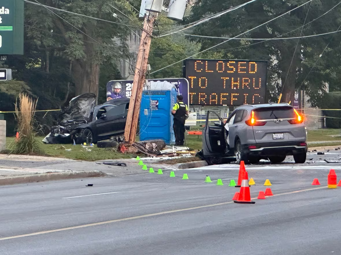 Two vehicles involved in collision with broken hydro pole visible. One vehicle on the front lawn of a home.