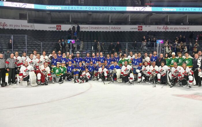 London Police and Fire personnel posing after a charity hockey game.