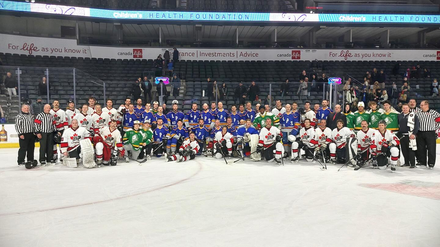 London Police and Fire personnel posing after a charity hockey game.