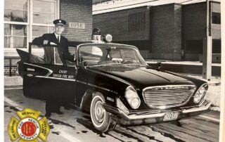 Fire Chief Mathers posing with his 1961 Chrysler Windsor in front of Station 1