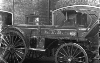 Black-and-white photograph of early 20th-century firefighters posing with a horse-drawn hose wagon in front of a fire station in London, Ontario.