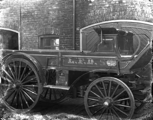 Black-and-white photograph of early 20th-century firefighters posing with a horse-drawn hose wagon in front of a fire station in London, Ontario.