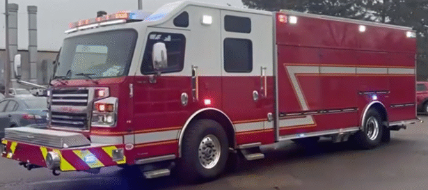 White over red, not decaled London Fire Department heavy rescue truck parked outdoors, featuring a large enclosed rescue body, emergency lighting, and reflective safety markings.